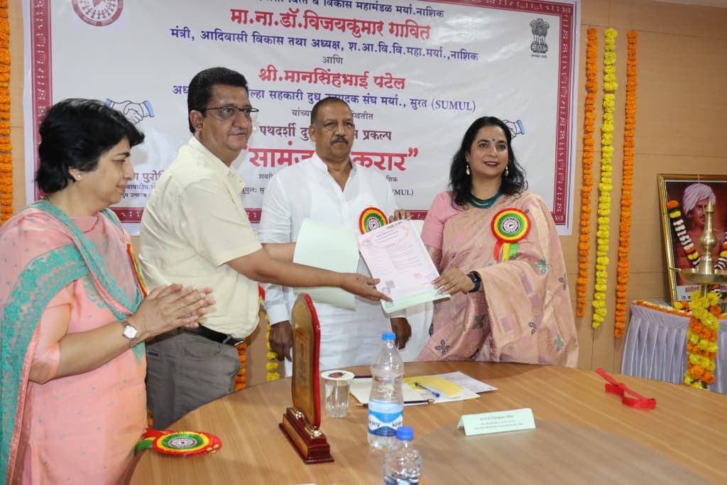 शबरी आदिवासी वित्त व विकास महामंडळ आणि सुरत जिल्हा सहकारी दुध उत्पादक संघ (सुमुल) यांच्यातील पथदर्शी दुग्ध विकास प्रकल्पाच्या सामंजस्य कराराची स्वाक्षरी झालेली प्रत सुपूर्द करतानाचे दृश्य